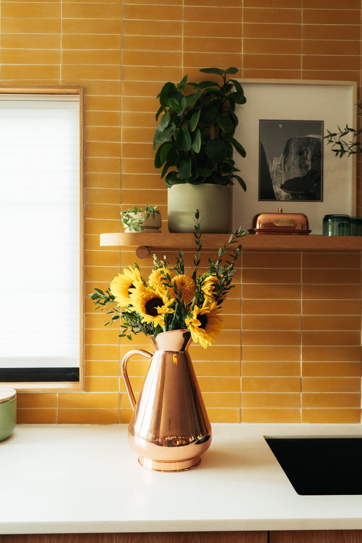 Galley & Fen copper heirloom vase with sunflowers on a kitchen counter