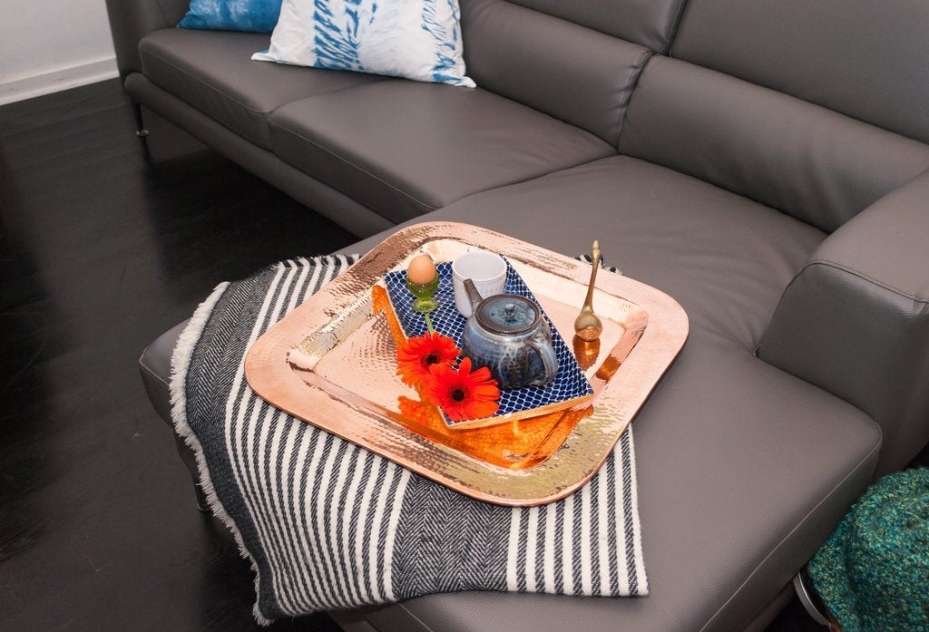 Sertodo Thessaly square copper platter used as a tray on a sofa