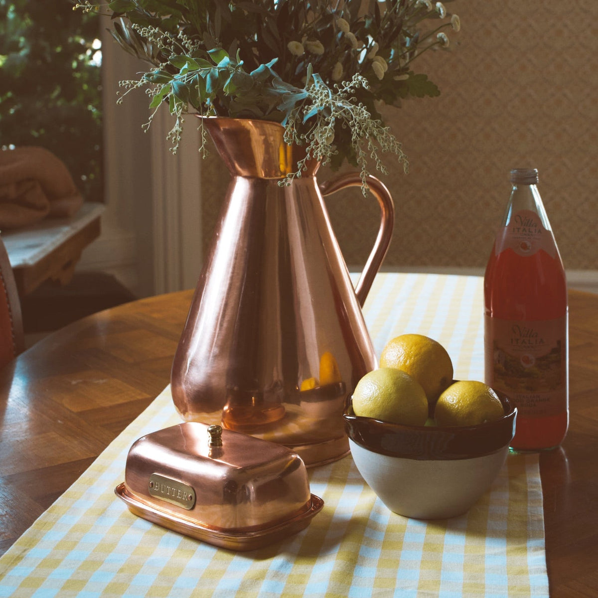 Galley & Fen copper heirloom vase on a table with lemons and copper butter dish
