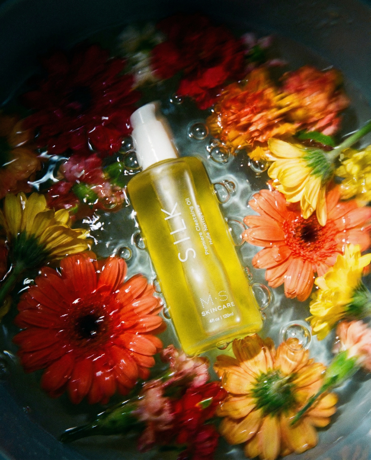 Silk Cleansing Oil in water surrounded by bright,colorful flowers on msksincare.co