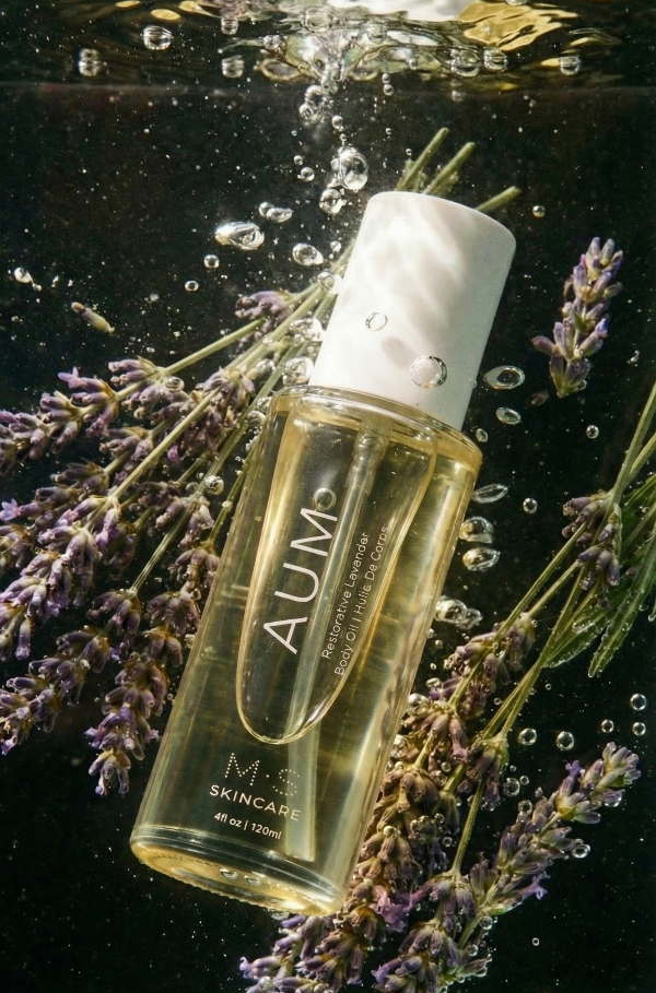 AUM skincare bottle surrounded by lavender flowers underwater