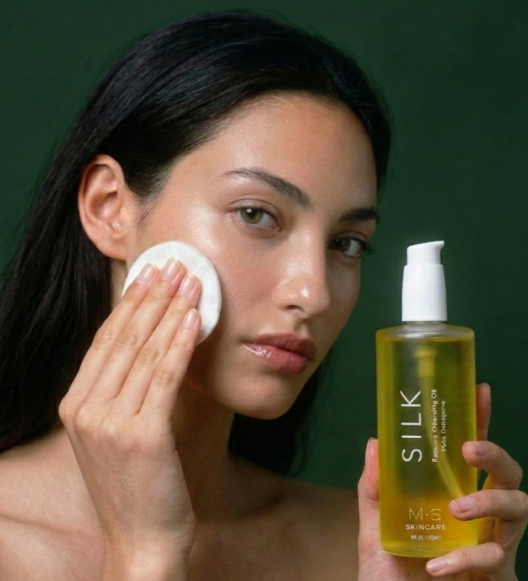 Woman applying Silk cleansing oil with a green background on msskincare.co