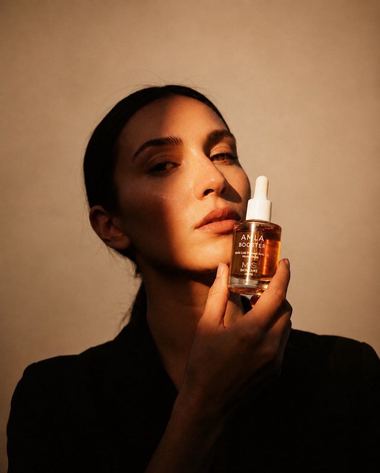 Woman holding Amla Oil in golden light