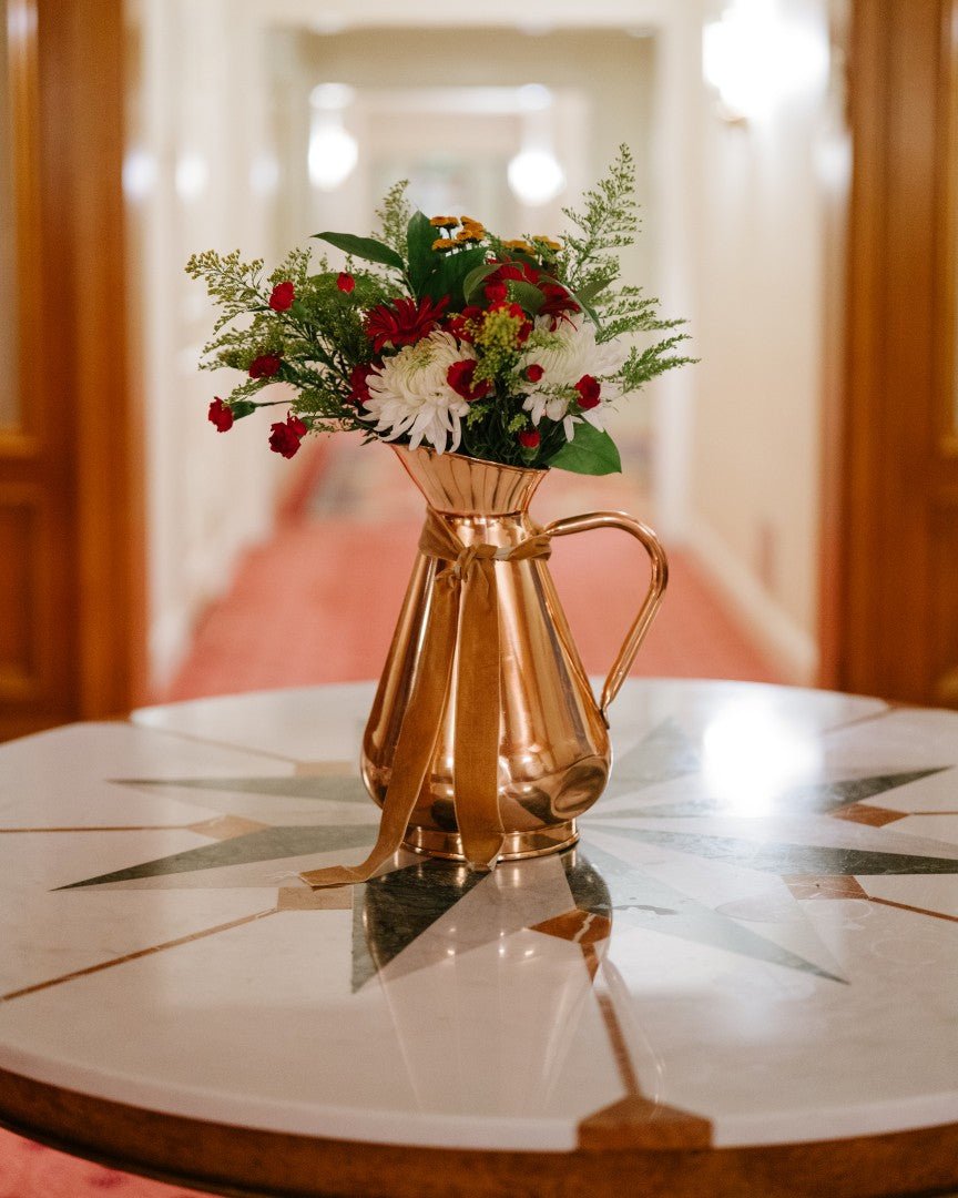 Galley & Fen large copper heirloom vase with flowers on a round table