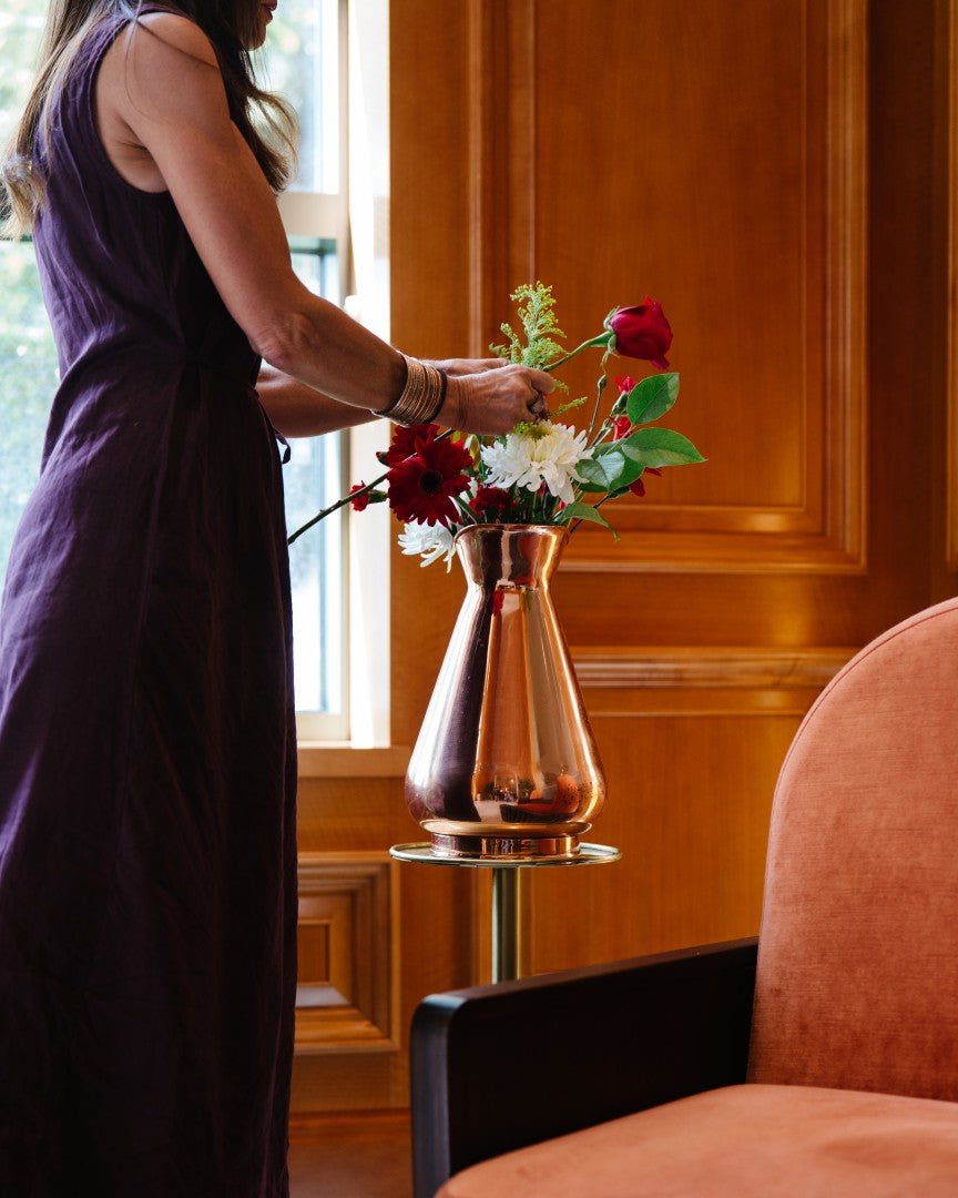 Woman arranging flowers in the Galley & Fen copper heirloom vase