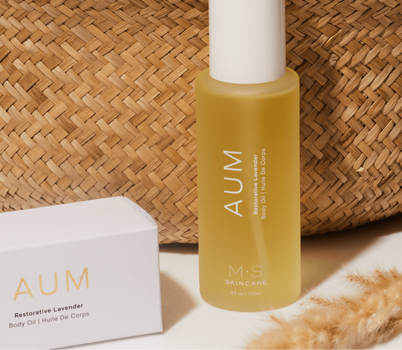 M.S Skincare AUM in a glass bottle in front a straw basket