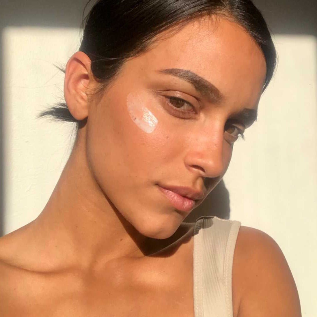 Rosewater Cream applied to an olive-skinned model, an Ayurvedic face moisturizer with Rose Hydrosol, Neem, and Turmeric