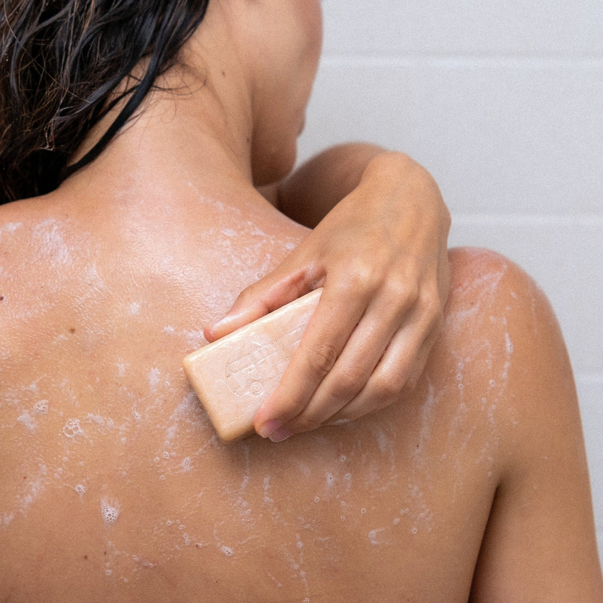 Woman washing her back with VanMan's Tallow & Honey Soap
